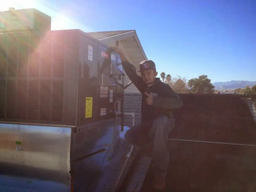 HVAC technician performing Air Duct Repair on a rooftop unit in Waynesboro